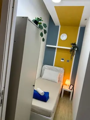 a small room with a couch and a shelf at Lovely Partition Room in Barsha 1 Near Metro in Dubai