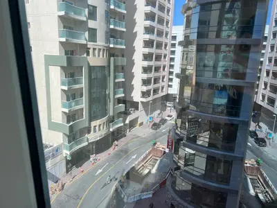 a view from a window of a city with tall buildings at Partition Room With Window Near MOE Metro in Dubai
