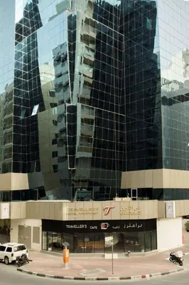 a large glass building with a car parked in front of it at Partition Room With Window Near MOE Metro in Dubai