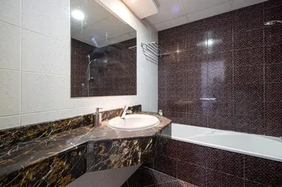 a bathroom with a sink and a tub and a mirror at Luxury 1 Bedroom Full Marina View, Sleeps 6, 1 Min to Metro in Dubai