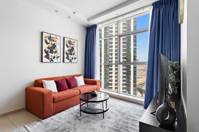 a living room with a couch and a large window at StoneTree - Fully Furnished 1BR in Dubai Marina in Dubai