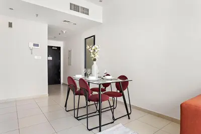 a dining room with a table and red chairs at StoneTree - Fully Furnished 1BR in Dubai Marina in Dubai