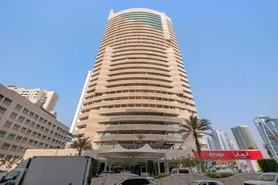 a tall building with cars parked in front of it at StoneTree - Furnished 1BR with Spacious Balcony in Dubai