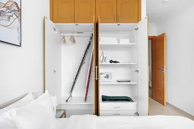a bedroom with a bed and a closet at StoneTree - Furnished 1BR with Spacious Balcony in Dubai