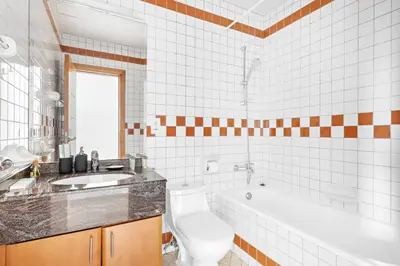 a bathroom with a toilet and a tub and a sink at StoneTree - Furnished 1BR with Spacious Balcony in Dubai