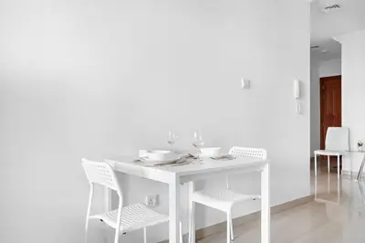 a white table with white chairs and a white table and chairsktop at StoneTree - Furnished 1BR with Spacious Balcony in Dubai