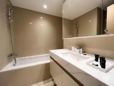 a bathroom with two sinks and a mirror and a tub at Luxurious Apt with breathtaking view in Downtown in Dubai