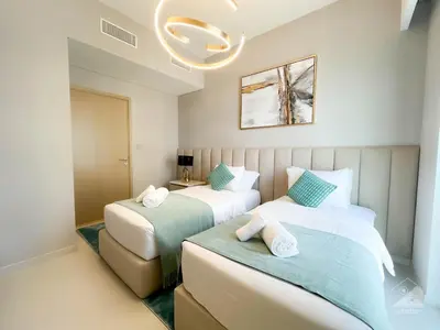 a bedroom with two beds and a chandelier at Luxurious Apt with breathtaking view in Downtown in Dubai