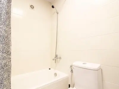 a white bathroom with a tub and a toilet at Cozy 1 BR in Dubai Marina in Dubai