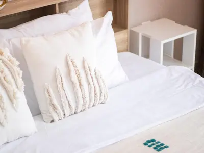 a bed with white sheets and pillows on it at Cozy 1 BR in Dubai Marina in Dubai