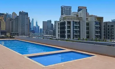 a swimming pool on the roof of a building with a city at Cozy 1 BR in Dubai Marina in Dubai