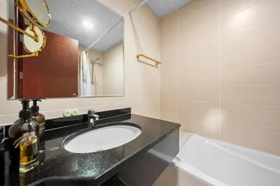 a bathroom with a sink and a mirror and a tub at Studio in Dubai