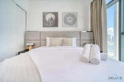 a bedroom with a large white bed with white pillows at Inviting 1BR at Beach Vista Tower 1 Emaar Beachfront Dubai Marina by Deluxe Holiday Homes in Dubai