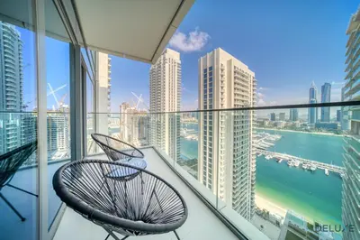 a balcony with two chairs and a view of the city at Inviting 1BR at Beach Vista Tower 1 Emaar Beachfront Dubai Marina by Deluxe Holiday Homes in Dubai