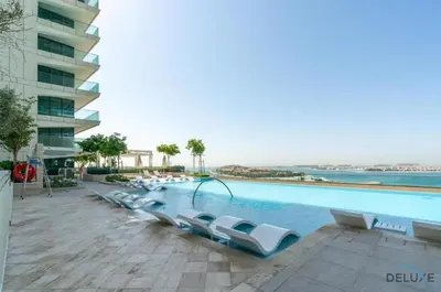 a swimming pool with lounge chairs next to a building at Inviting 1BR at Beach Vista Tower 1 Emaar Beachfront Dubai Marina by Deluxe Holiday Homes in Dubai