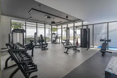 a gym with treadmills and chairs and windows at Inviting 1BR at Beach Vista Tower 1 Emaar Beachfront Dubai Marina by Deluxe Holiday Homes in Dubai