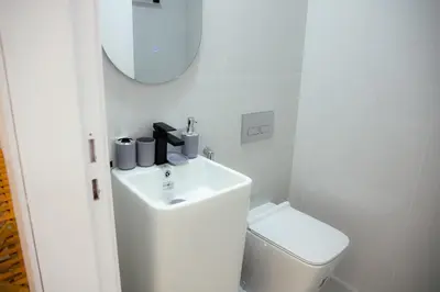 a bathroom with a sink and a toilet and a mirror at Jumeriah Lake Tower(JLT)- (MAG214)(2) in Dubai
