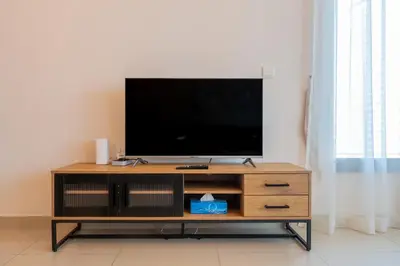 a flat screen tv sitting on top of a wooden entertainment center at Bella Vista - 29 Boulevard Downtown - 2BR - Partial Fountain View in Dubai