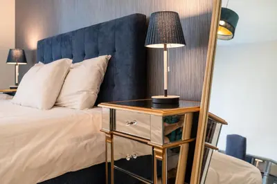 a bedroom with a bed with a mirror and a lamp at Bella Vista - 29 Boulevard Downtown - 2BR - Partial Fountain View in Dubai
