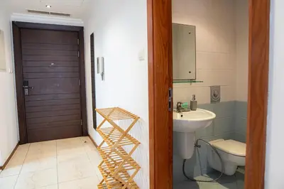 a bathroom with a sink and a toilet and a wooden door at Jumeriah Lake Tower (JLT)-(MAG214)(1) in Dubai