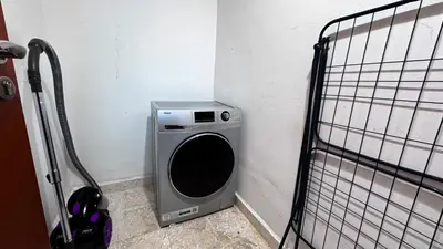 a washing machine in a corner of a room at Jumeriah Lake Tower (JLT)-(MAG214)(1) in Dubai