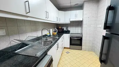 a kitchen with a dish drying rack on the sink at Jumeriah Lake Tower (JLT)-(MAG214)(1) in Dubai