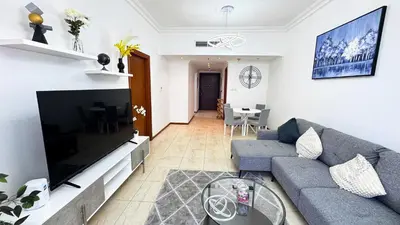 a living room with a couch and a tv at Jumeriah Lake Tower (JLT)-(MAG214)(1) in Dubai