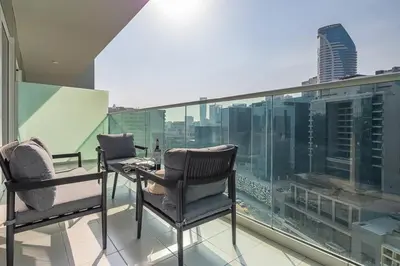 a balcony with two chairs and a view of a city at Frank Porter - Reva Residences in Dubai