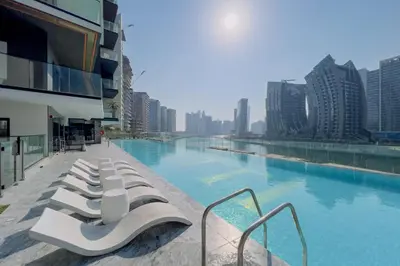 a row of white lounge chairs sitting next to a swimming pool at GuestReady - Mesmerizing views of the Burj Khalifa in Dubai