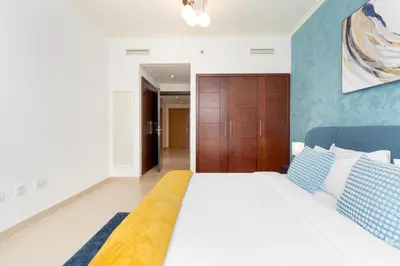 a bedroom with a large bed with blue and white pillows at Lux BnB Burj Views Tower I Downtown in Dubai