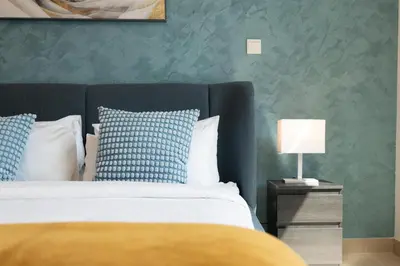 a bedroom with a bed and a green wall at Lux BnB Burj Views Tower I Downtown in Dubai