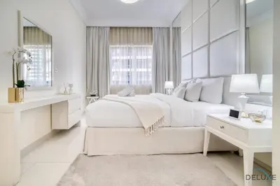 a white bedroom with a large bed and a mirror at Chic 1BR at The Signature Downtown Dubai by Deluxe Holiday Homes in Dubai