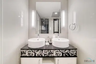 a bathroom with two sinks and a mirror at Chic 1BR at The Signature Downtown Dubai by Deluxe Holiday Homes in Dubai