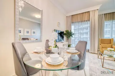 a dining room with a glass table and chairs at Chic 1BR at The Signature Downtown Dubai by Deluxe Holiday Homes in Dubai