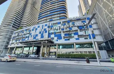 a blue and white building with cars parked in front of it at Chic 1BR at The Signature Downtown Dubai by Deluxe Holiday Homes in Dubai