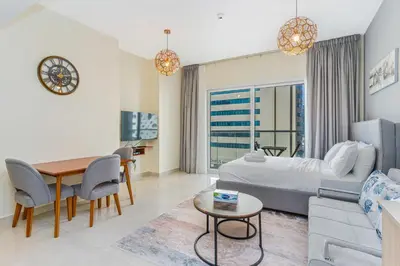 a living room with a bed and a dining room at Studio with Balcony Skyline View Business Bay in Dubai