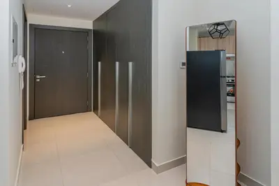 a hallway with a black refrigerator and a kitchen at Studio with Balcony Skyline View Business Bay in Dubai