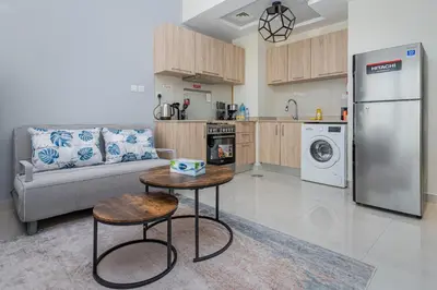 a kitchen and living room with a refrigerator and a table at Studio with Balcony Skyline View Business Bay in Dubai