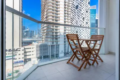 a balcony with two chairs and a view of a city at Studio with Balcony Skyline View Business Bay in Dubai