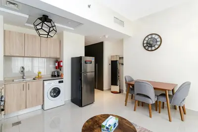a kitchen and dining room with a table and a refrigerator at Studio with Balcony Skyline View Business Bay in Dubai
