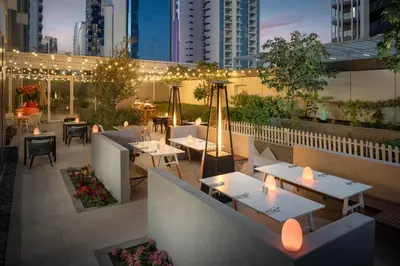 a rooftop restaurant with tables and chairs and lights at Staybridge Suites Dubai Business Bay by IHG in Dubai