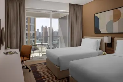 a hotel room with two beds and a balcony at Staybridge Suites Dubai Business Bay by IHG in Dubai