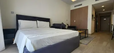 a bedroom with a large bed and a chair at Luxury Studio, 15m to Dubai Mall! in Dubai