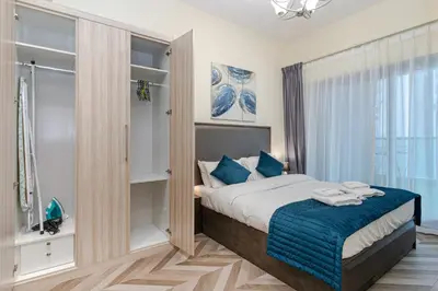 a bedroom with a bed with blue pillows at Contemporary furnishing I City skyline view in Dubai