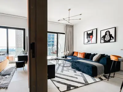 a living room with a blue couch in a white room at Trophy - Luxury Canal View Suites. in Dubai