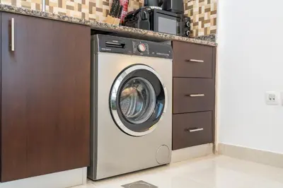 a washing machine in a kitchen next to a counter at Comfortable Broad Studio in Business Bay-Suiteable in Dubai