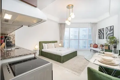 a kitchen and living room with a bed and a table at Comfortable Broad Studio in Business Bay-Suiteable in Dubai