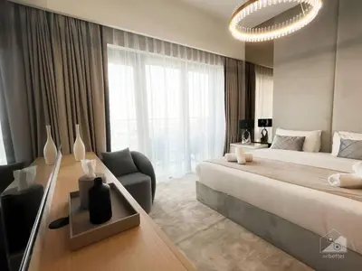 a large bedroom with a large bed and a chair at NEW! Modern Elegance 2B in Burj Royale Downtown in Dubai