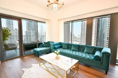 a living room with a blue couch and large windows at Burj Roayle-Magical Burj & Fountain Sky Views 3+1 BR APT in Dubai
