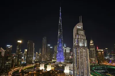 a nighttime view of a city with a tall building at Burj Roayle-Magical Burj & Fountain Sky Views 3+1 BR APT in Dubai